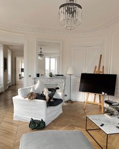 a woman laying on top of a white couch in a living room