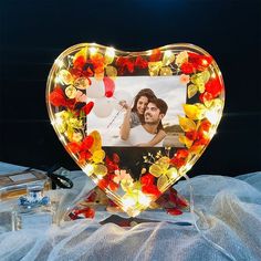 a heart shaped glass photo frame with flowers on it