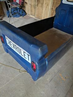 a blue truck bed with the word chevrolet written on it's back end in a garage