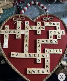 a heart shaped scrabble with words written on it and beads around the edges