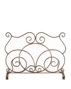 an iron fireplace screen with scroll designs on the top and bottom, set against a white background