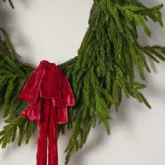 a green wreath with red ribbon hanging from it