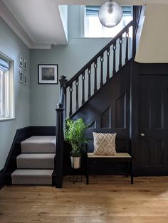 a stair case next to a set of stairs with a plant on the bench in front of it