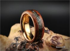 a wooden ring with black and gold inlays