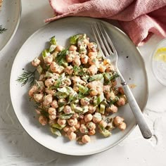 a white plate topped with chick salad next to a fork