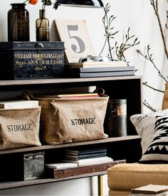 a living room filled with lots of furniture and bags on top of a book shelf