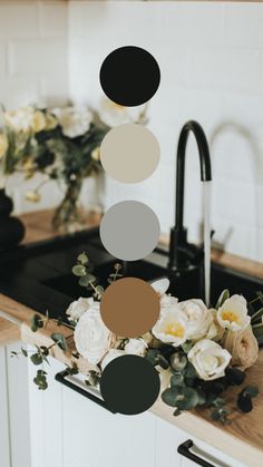 a kitchen counter with flowers and black faucet