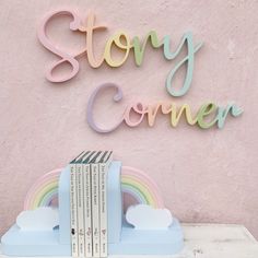 a stack of books sitting on top of a table next to a sign that says story corner