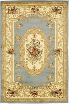 a blue and beige rug with gold trimmings on the border, surrounded by flowers