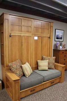 a wooden bench with pillows on it in a room