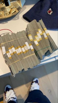 a person standing next to stacks of money