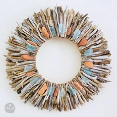 a wreath made out of driftwood sticks and seashells on a white background