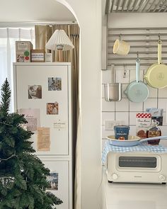 a white refrigerator freezer sitting next to a christmas tree