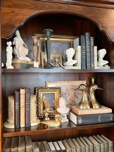 an old book shelf with books and figurines on it