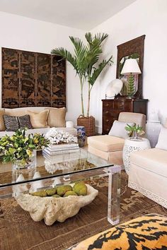 a living room filled with furniture and a glass coffee table in front of a couch