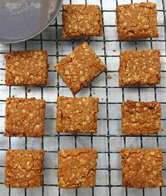 several squares of oatmeal bars on a cooling rack next to a bowl