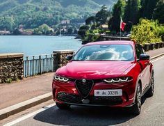 a red alfa car driving down the road