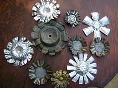 an assortment of metal flowers sitting on top of a wooden table