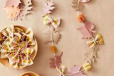 a table topped with lots of different types of crafts and yarn next to a bowl of candy