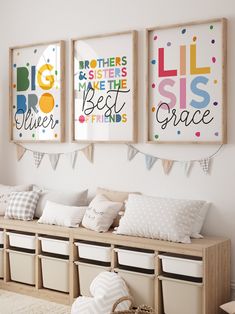 three framed pictures hang on the wall in a child's room with storage bins