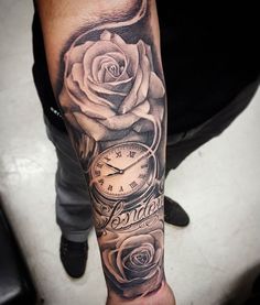 a man's arm with a rose and clock tattoo on it, along with the word roses