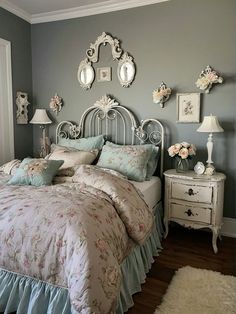 a bedroom with a bed, dresser and two mirrors on the wall above it's headboard