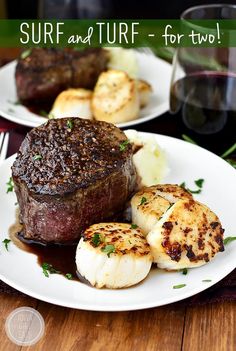 steak, scallops and potatoes are served on two white plates next to a glass of red wine