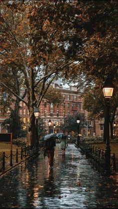 two people walking down the street in the rain with umbrellas over their heads,