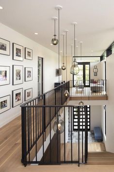 an open staircase in a modern home with pictures on the wall