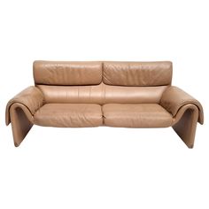 a tan leather couch with curved arms and legs on an isolated white background for display