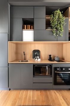 a kitchen with wooden floors and gray cabinets, including an oven and stove top combination