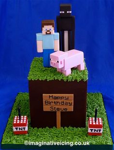 a birthday cake made to look like minecraft characters on top of a field with grass