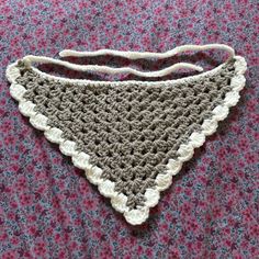 a crocheted bib laying on top of a pink blanket