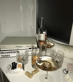 two wine glasses and some books on a table