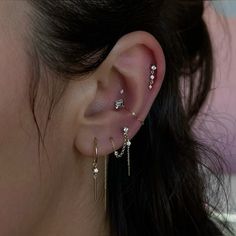 a close up of a person's ear with three different piercings on it