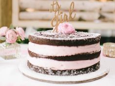 a pink and brown cake sitting on top of a table