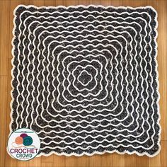 a black and white rug with an interlaced design on the center, in front of