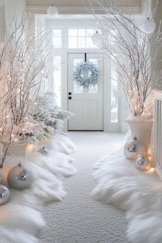 white christmas decorations in front of a door with lights on the trees and snowflakes