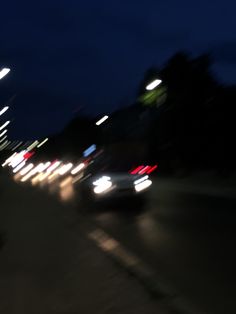 blurry image of cars driving down the street at night