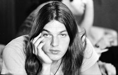 black and white photograph of a man with long hair sitting in front of a laptop computer