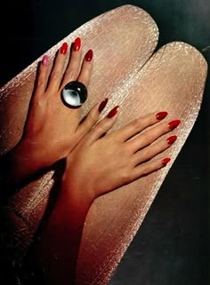 a woman's feet with red nail polish and an oval ring on her toe