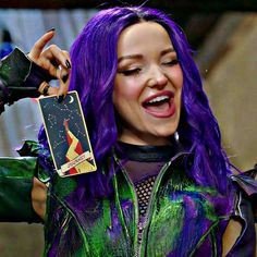 a woman with purple hair holding up a card