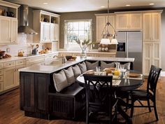 a large kitchen with an island table and chairs