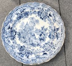 a blue and white plate sitting on the ground