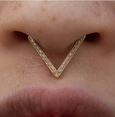 a woman's nose with a gold chevron ring on top of her nose