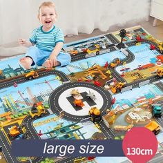 a child sitting on top of a play mat with construction vehicles and trucks around it