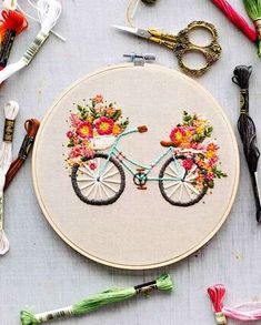 a close up of a embroidery on a table with scissors and other crafting supplies