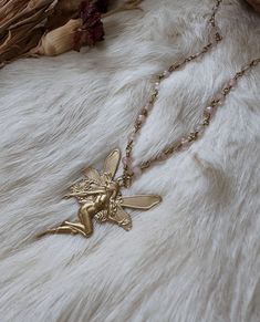 These gorgeous ethereal necklaces are made out of real rose quartz beads and brass chain. The fairy charm is vintage brass. These necklaces make a beautiful complement to any occasion and outfit 🦋 ️  Unleash your inner ethereal fairy 🌙 Necklace length I'm wearing is 19 inches Fairies and nymphs are a bit different in comparison but also very alike. Nymphs are usually human sized and extremely beautiful and ethereal beings. Fairies and pixies are tiny human like creatures who are usually little Fairy Pendant Necklace, Ethereal Handmade Gold Necklaces, Bohemian Gold Rose Quartz Jewelry, Fairycore Beaded Jewelry For Festivals, Fairycore Beaded Festival Jewelry, Fairycore Beaded Jewelry Gift, Handmade Bohemian Rose Quartz Beaded Necklaces, Bohemian Rose Quartz Pendant Necklace, Festival Fairycore Beaded Jewelry