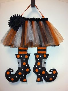 a pair of boots hanging from a wall with tulle skirt and polka dot socks on it