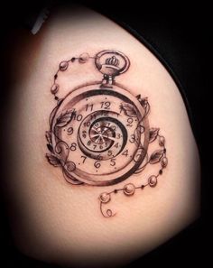 a clock tattoo on the side of a woman's thigh